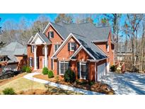 Beautiful brick two-story home with manicured landscaping, gray roof, and black shutters at 1105 River Laurel Dr, Suwanee, GA 30024
