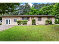 Charming single-story home featuring a well-maintained lawn and lush greenery at 624 Lyle Se Dr, Marietta, GA 30067