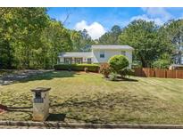 Charming two-story home featuring lush landscaping and a well-manicured lawn with mature trees at 1007 Wayne Dr, Snellville, GA 30078