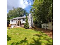 Charming two-story home featuring a well-manicured front lawn and classic architectural design at 710 Singing Hills Ct, Roswell, GA 30076