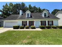Charming one-story home with manicured lawn and mature trees creates a welcoming curb appeal at 1050 Redan Trce, Stone Mountain, GA 30088