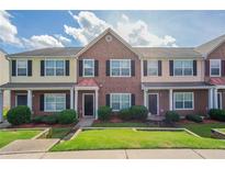 Charming townhome featuring brick facade, black shutters, and well-maintained landscaping at 4544 Parkview Sq, Atlanta, GA 30349