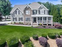 Beautiful two-story home boasts a manicured lawn, stone accents, and a welcoming front porch at 106 Twilight Overlook, Canton, GA 30114