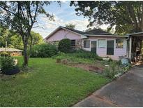 Modest one-story home featuring a spacious front lawn and mature trees at 3838 Dunbury Ln, Decatur, GA 30032