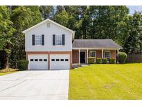 Charming two-story home with attached two-car garage and well-manicured lawn and black window shutters at 6541 Lazy Creek Ct, Lithonia, GA 30058
