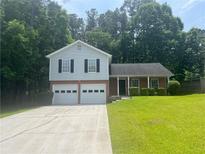 Charming two-story home features a two-car garage, brick accents, and a well-maintained front yard at 6541 Lazy Creek Ct, Lithonia, GA 30058