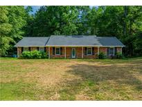 Charming one-story brick home with a well-maintained lawn and mature trees, offering a cozy and inviting curb appeal at 299 Fieldview Dr, Auburn, GA 30011