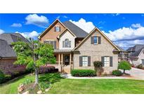 Stunning two-story home with manicured lawn, brick facade, and a welcoming front porch at 1054 Morgan Garner Sw Dr, Lilburn, GA 30047