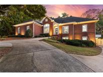 Beautiful brick home featuring a well-manicured lawn, mature trees, and an elegant driveway at 248 Montrose Dr, Mcdonough, GA 30253