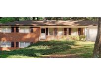 Charming brick home with well-kept lawn and mature trees, enhancing its curb appeal at 5582 Brady Dr, Stone Mountain, GA 30087