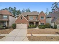 Charming two-story brick home featuring a well-manicured front yard and attached two-car garage at 2126 Roberts View Trl, Buford, GA 30519