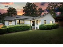 Charming painted brick home with black trim, dark roof, landscaped yard, and solar panels at 3734 Powers Ferry Nw Rd, Atlanta, GA 30342