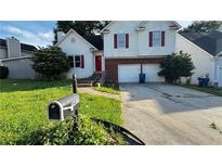 Charming two-story home with an attached garage and a well-manicured front lawn at 5415 Twin Lakes Dr, Atlanta, GA 30349