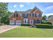 Charming brick home boasts a well-manicured lawn, attached two-car garage, and a welcoming front entrance at 1124 Monarda Nw Way, Acworth, GA 30102