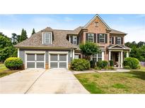 Charming two-story brick home with a manicured lawn and two-car garage at 1045 Fords Crossing Nw Dr, Acworth, GA 30101
