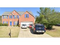 Charming two-story brick home with blue shutters and a well-manicured lawn in a suburban neighborhood at 1685 Great Oaks Dr, Lawrenceville, GA 30045