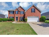 Charming two-story red brick home features a manicured lawn and a two-car garage at 1685 Great Oaks Dr, Lawrenceville, GA 30045