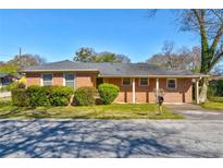 Charming brick home with a well-maintained lawn and neatly trimmed bushes enhancing its curb appeal at 5136 Jones Rd, Forest Park, GA 30297