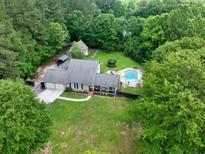 Beautiful home with pool, trampoline, two-car garage and fully fenced backyard nestled among mature trees and a lush green lawn at 955 Chandler Haulk Rd, Loganville, GA 30052
