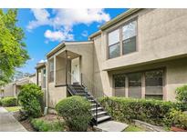 Two-story condo featuring a cozy front porch with stairs leading to the entrance and manicured landscaping at 1719 Woodcliff Ne Ct, Atlanta, GA 30329