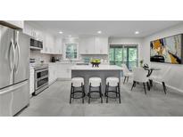 Bright kitchen features stainless appliances, white cabinets and a gray island with bar stool seating at 5400 Mill Run Dr, Marietta, GA 30068