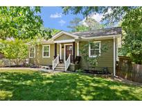 Charming single-story home with green siding, a landscaped front yard, and inviting front porch with bench seating at 1734 8Th St, Atlanta, GA 30341