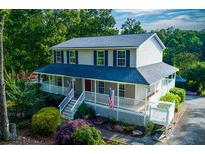 Charming two-story home featuring a spacious wrap-around porch and a well-maintained yard in a wooded setting at 2024 Lower Burris Road Rd, Canton, GA 30114