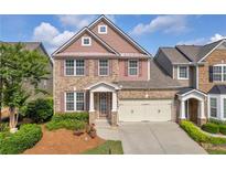 Charming two-story brick home with a well-maintained lawn, attached two car garage, and classic architectural details at 2677 Sardis Chase Ct, Buford, GA 30519