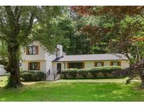 Charming home with a lush green lawn and mature trees providing shade and character at 3308 Quail Run Sw Sw Run, Marietta, GA 30008