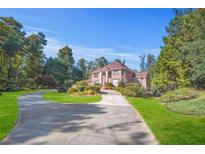 Brick home with circular driveway and manicured lawn at 7523 Kimberly Lynn Ct, Lithonia, GA 30058