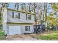 Charming split-level home with a one-car garage, gray siding, and black shutters nestled amongst trees at 840 Wells Se Cir, Smyrna, GA 30080