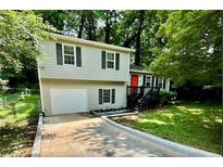 Charming two-story home featuring a well-maintained front yard, a garage and a striking red front door at 840 Wells Se Cir, Smyrna, GA 30080
