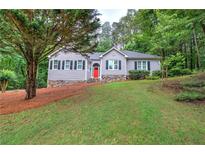 Charming single-story home features a manicured lawn, stone accents, and a welcoming red front door at 23 Timberlake Pointe Ne, Cartersville, GA 30121