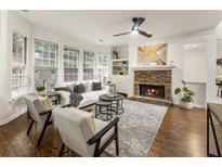 Bright living room featuring stone fireplace, large windows, hardwood floors, and a neutral color palette at 5860 Fairway View Dr, Suwanee, GA 30024