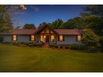 Charming single-story home featuring a well-manicured lawn and inviting entrance at dusk at 3769 Bay Creek Church Rd, Loganville, GA 30052