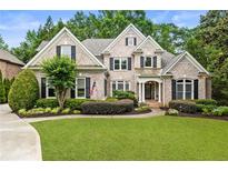 Charming two-story brick home with lush landscaping and a well-manicured lawn at 8970 Moor Park Run, Duluth, GA 30097
