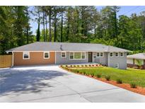 Beautiful single story home featuring new landscaping and a long concrete driveway at 681 Fielding Sw Ln, Atlanta, GA 30311