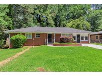 Charming brick home featuring a well-maintained lawn and mature trees at 3170 Bellgreen Way, Decatur, GA 30032