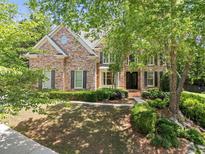 Brick two-story home with mature trees, well-manicured landscaping, and a charming entrance at 4250 Old Oak Trce, Cumming, GA 30041