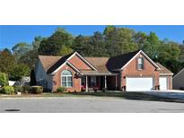 Charming brick home featuring an attached two-car garage and a welcoming covered front porch at 1382 Fountain Lakes Drive Dr, Lawrenceville, GA 30043