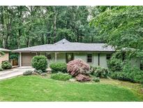 Charming single-story home featuring a landscaped front yard and an attached garage nestled in a wooded setting at 2786 Overlook Ne Dr, Atlanta, GA 30345