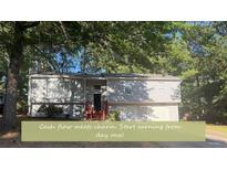 Charming home with a well-maintained exterior and a lush, tree-filled front yard at 4191 Alaina Circle Cir, Austell, GA 30106