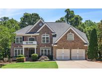 Charming brick home with a manicured lawn, mature trees, and an attached two-car garage at 5059 Belair Bluff Se Ct, Smyrna, GA 30126
