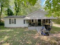 Charming single-story home with a covered porch, surrounded by mature trees and a green lawn at 6385 Highway 92, Fairburn, GA 30213
