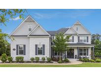 Charming two-story brick home featuring gray shutters, a manicured lawn, and a welcoming front porch at 1865 Henley Way, Alpharetta, GA 30009