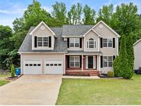 Charming two-story home boasts a manicured lawn, brick accents, and an attached two-car garage at 1897 Alcovy Trace Way Way, Lawrenceville, GA 30045