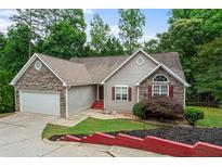 Charming one-story home featuring stone accents, a two-car garage, and mature landscaping at 2701 Windsor Nw Ct, Kennesaw, GA 30144