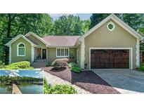 Charming one-story home with manicured landscaping, a two-car garage, and views of the lake at 2825 Lake Ct, Cumming, GA 30041