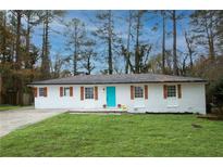 Charming brick ranch with a striking turquoise door and well-manicured lawn at 3893 Bonnie Se Ln, Atlanta, GA 30354
