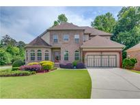 Beautiful two-story brick home with a well-manicured lawn and colorful landscaping at 764 Morganton Dr, Johns Creek, GA 30024